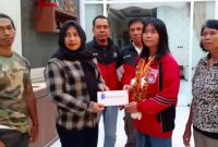 Anggota Dewan Perwakilan Rakyat Daerah (DPRD) Kabupaten Kapuas yang juga Ketua Cabor Pabersi Kapuas, Patna Wigati, didampingi pengurus Cabor, dan pelatih menyerahkan hadiah kepada Lifter Relly Wulandari, baru-baru tadi. (foto:ist)